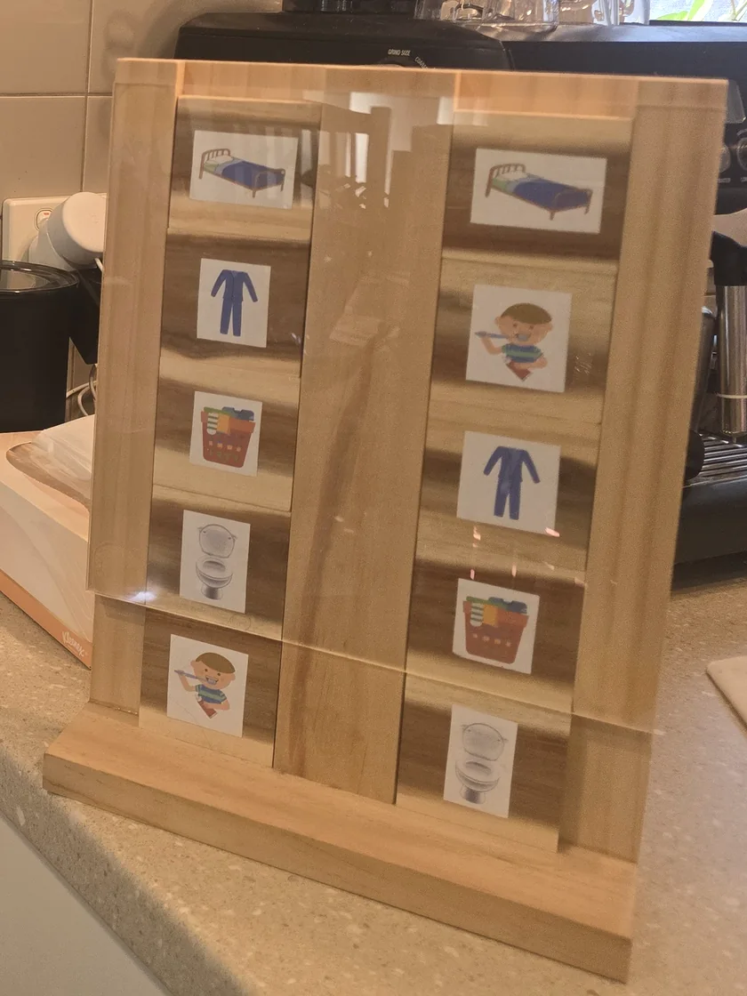 A handmade wooden chore board with picture cards for each job: bed, pyjamas, washing, toilet and teeth